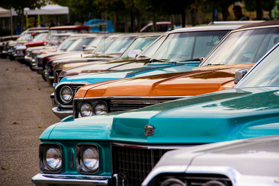 Una fila de coches clásicos vintage exhibidos al aire libre. Perfecto para los amantes de los coches y temas retro.