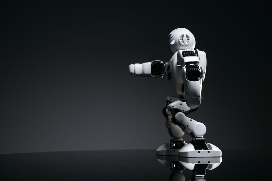 Un robot blanco que muestra un diseño moderno sobre una superficie oscura y elegante.