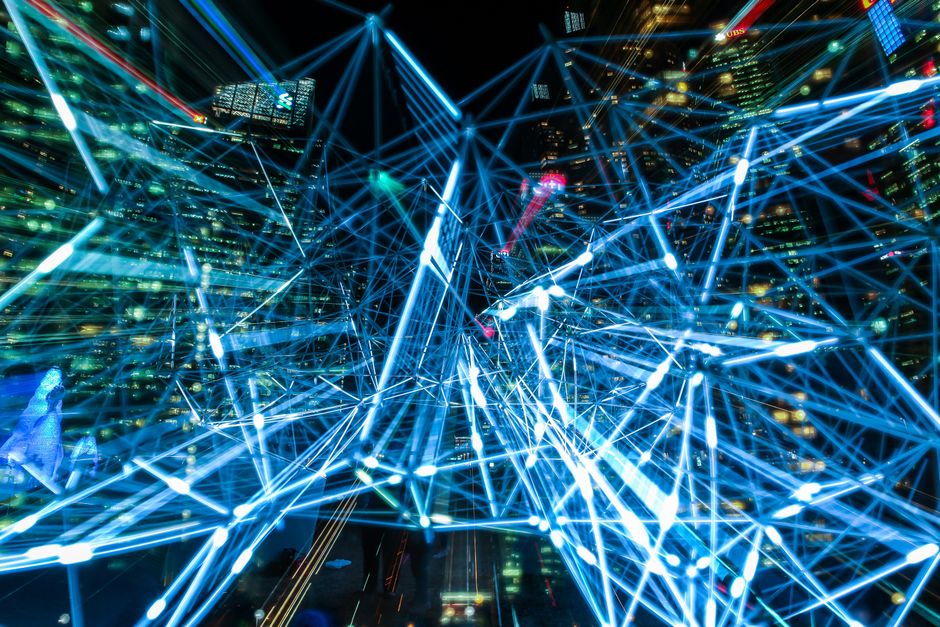 Escena urbana dinámica que muestra senderos de luz interconectados que representan redes de comunicación digital.