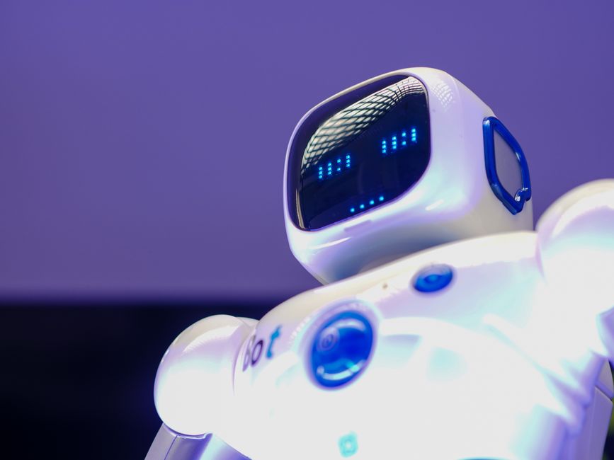 Un robot humanoide moderno con cara digital y pantalla luminosa, simbolizando la innovación en tecnología.