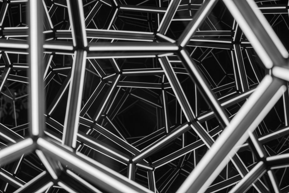 Intrincada estructura geométrica en blanco y negro que muestra un diseño abstracto moderno.