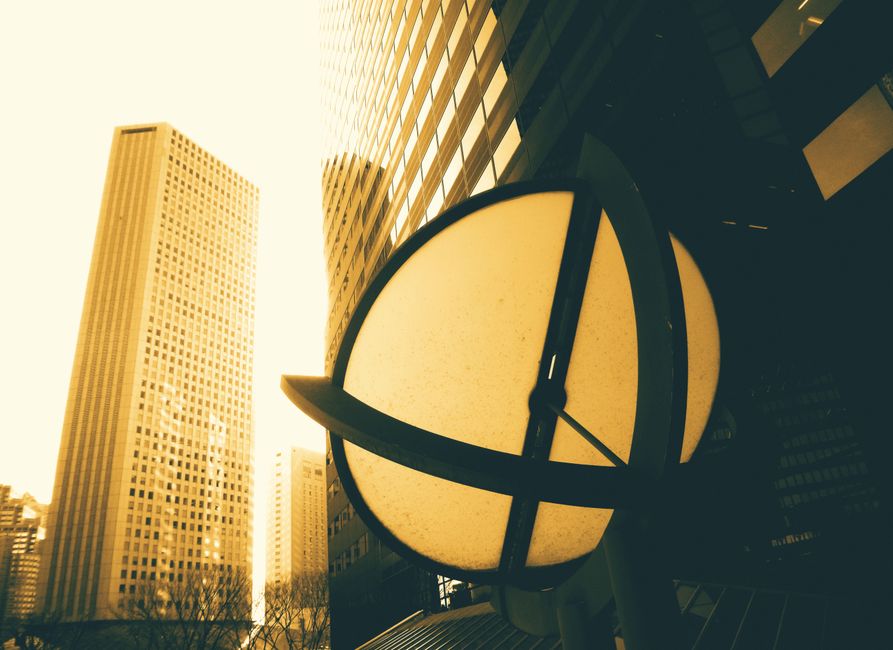 Vista en ángulo bajo de rascacielos modernos con un diseño único iluminado por el sol en un entorno urbano.
