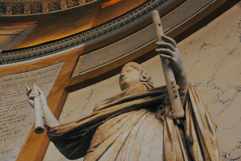 Primer plano de una estatua clásica en un monumento histórico de París, que muestra intrincados detalles arquitectónicos.