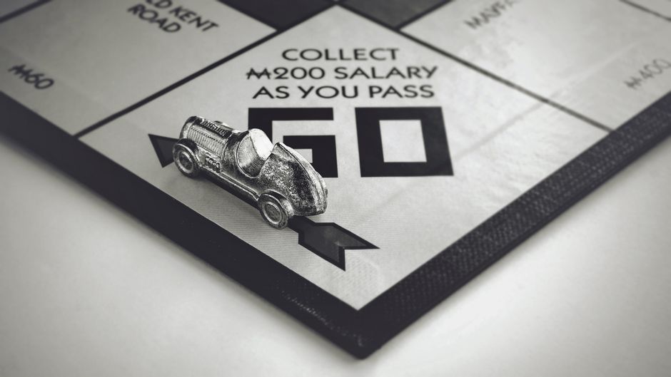 Close-up en blanco y negro de una pieza de coche de Monopoly en el juego de mesa.