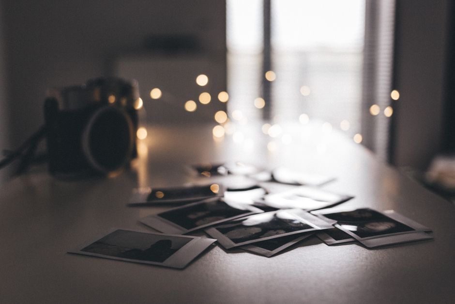 Foto de interior con atmósfera nostálgica, cámara vintage e impresiones Polaroid.