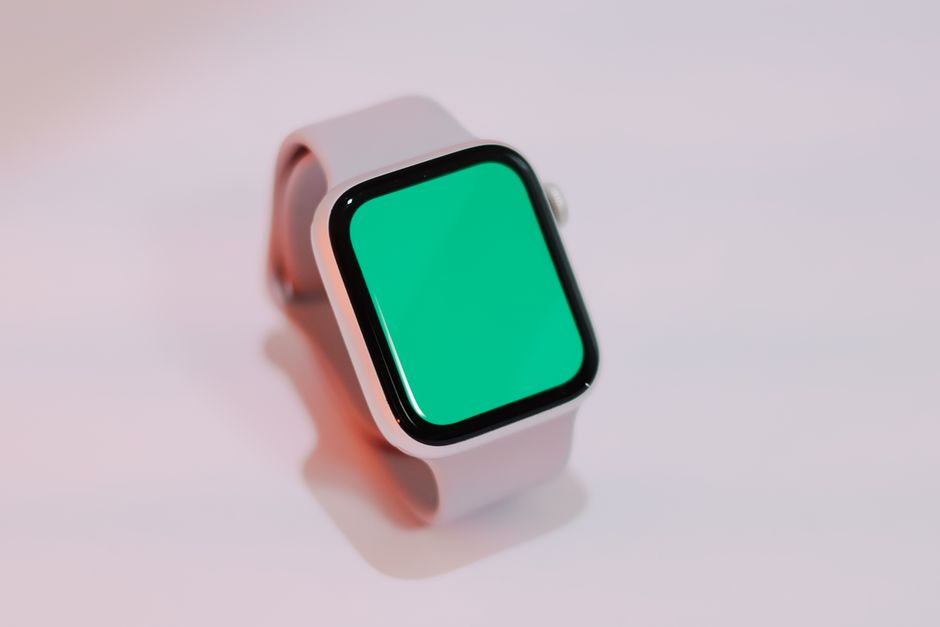 Reloj inteligente con una pantalla verde en blanco que se muestra sobre un fondo claro, adecuado para maquetas.