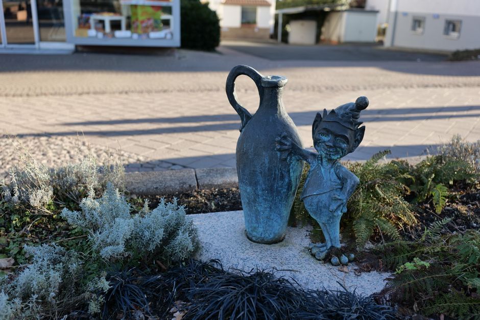 Estatua de gnomo con una jarra grande en un jardín en Bad Wildungen, Hessen, Alemania.