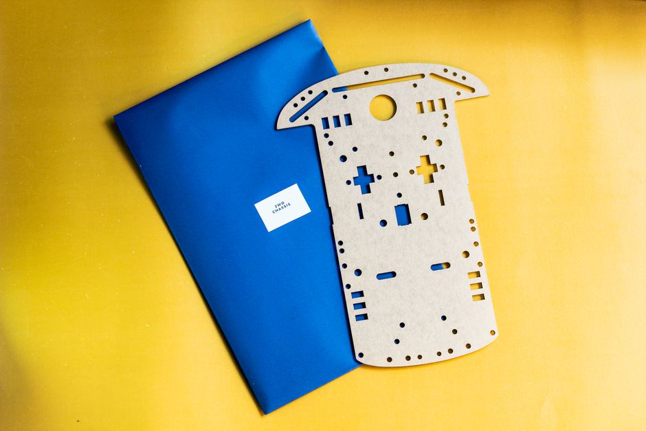 Componente de kit de robótica de madera sobre un fondo vibrante amarillo y azul.