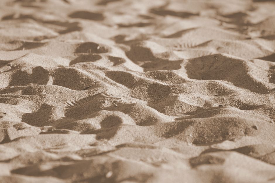 Primer plano detallado de dunas de arena que muestra texturas y patrones en luz natural.