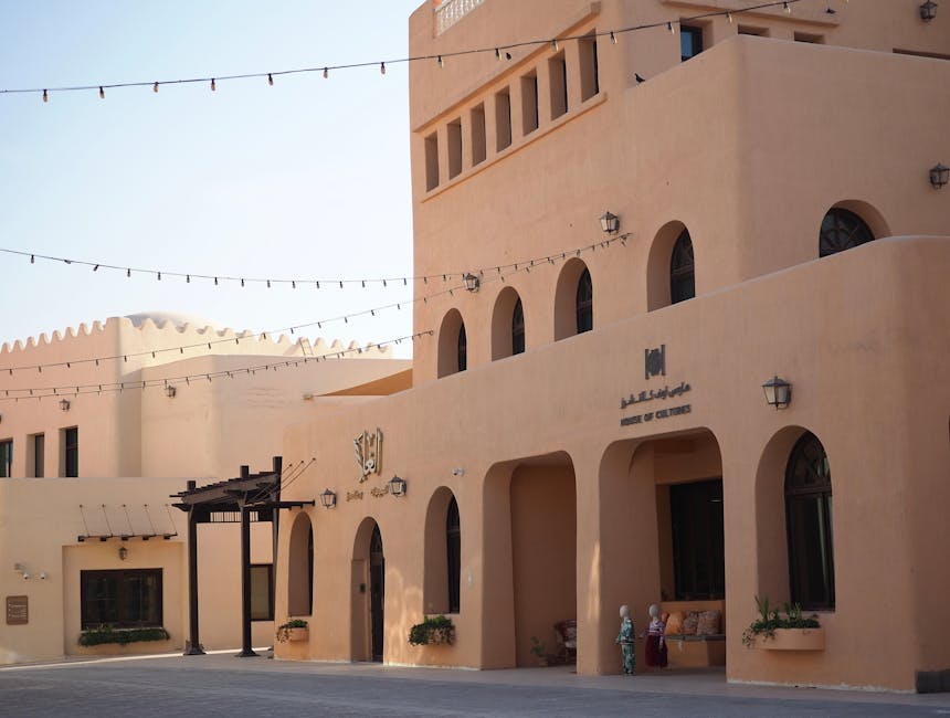Un edificio tradicional moderno con entradas arqueadas y paredes color melocotón en Qatar.