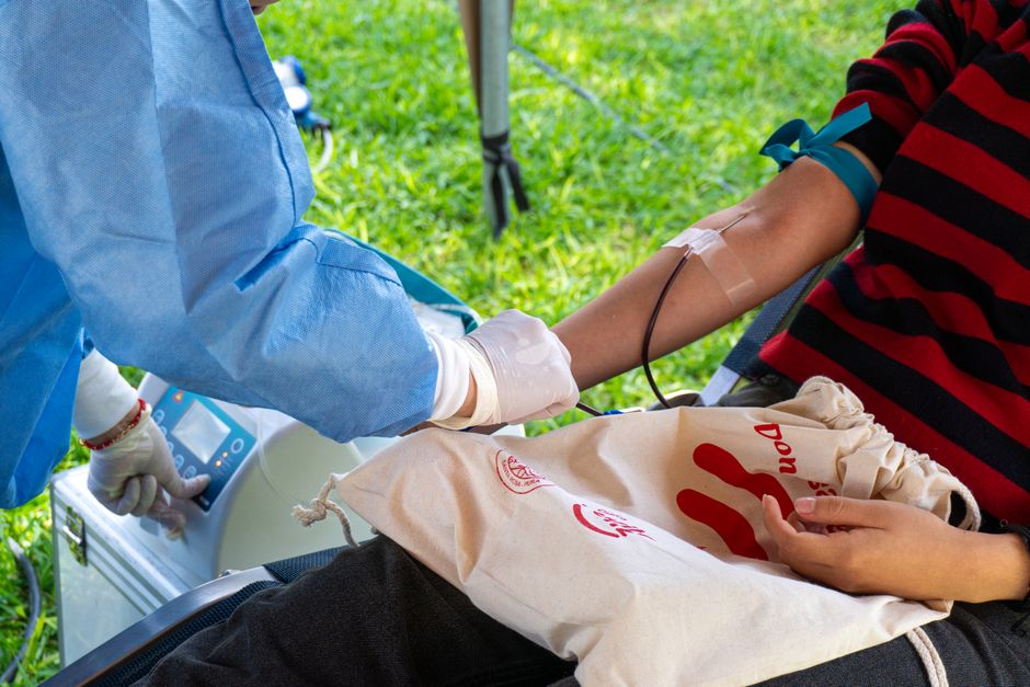 Una persona dona sangre al aire libre en Piura, Perú, haciendo hincapié en la importancia de la caridad para salvar vidas.