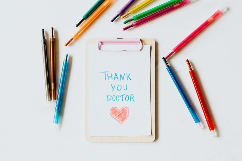 Nota de agradecimiento creativa para médicos en un portapapeles con bolígrafos simbolizando aprecio y gratitud.