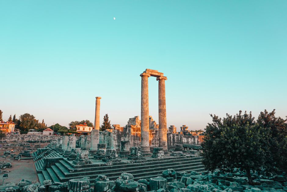 Vista cautivadora de las ruinas del Templo de Apolo al atardecer, mostrando columnas majestuosas contra un cielo azul.