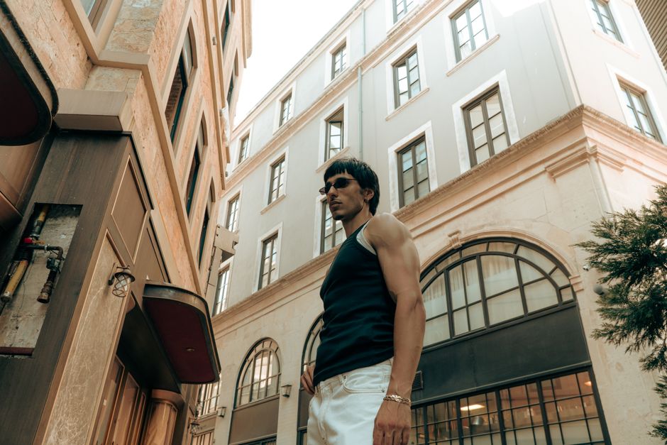 Un hombre elegante posa con confianza en un sofisticado entorno urbano de Estambul, luciendo moda moderna.