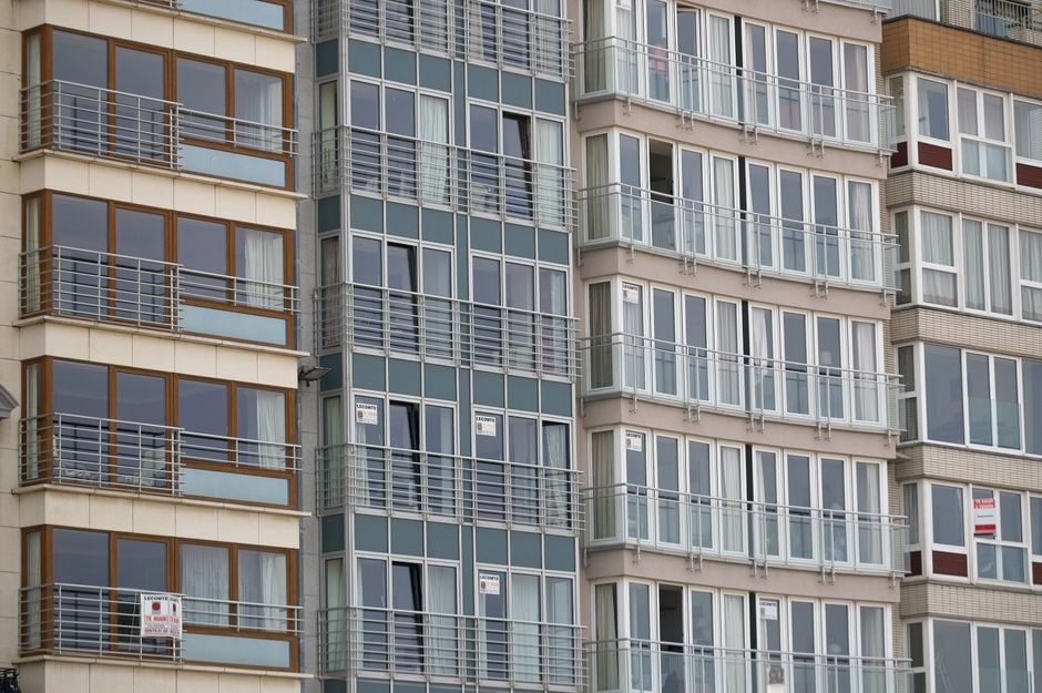 Vista cercana de la fachada de un moderno edificio residencial con grandes ventanas.