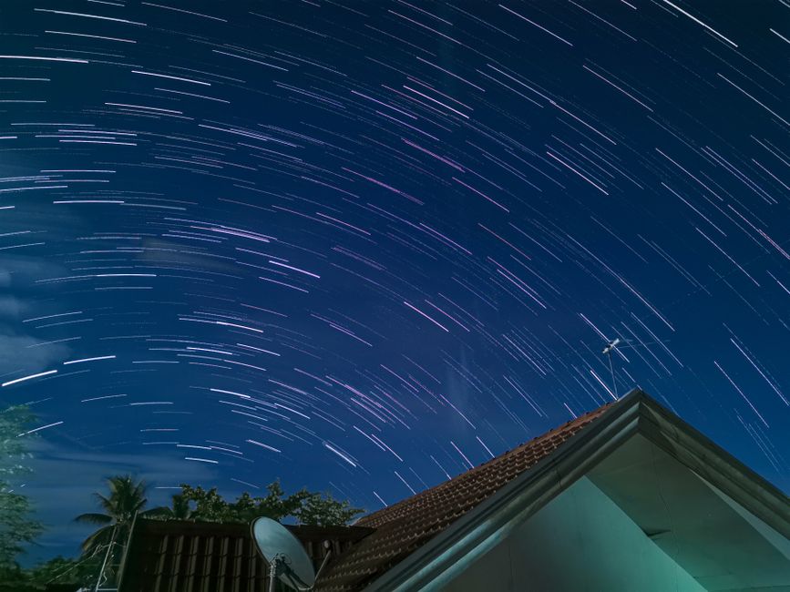 Impresionante fotografía de estelas de estrellas sobre un techo en la ciudad de Tagum, mostrando un vibrante cielo nocturno.