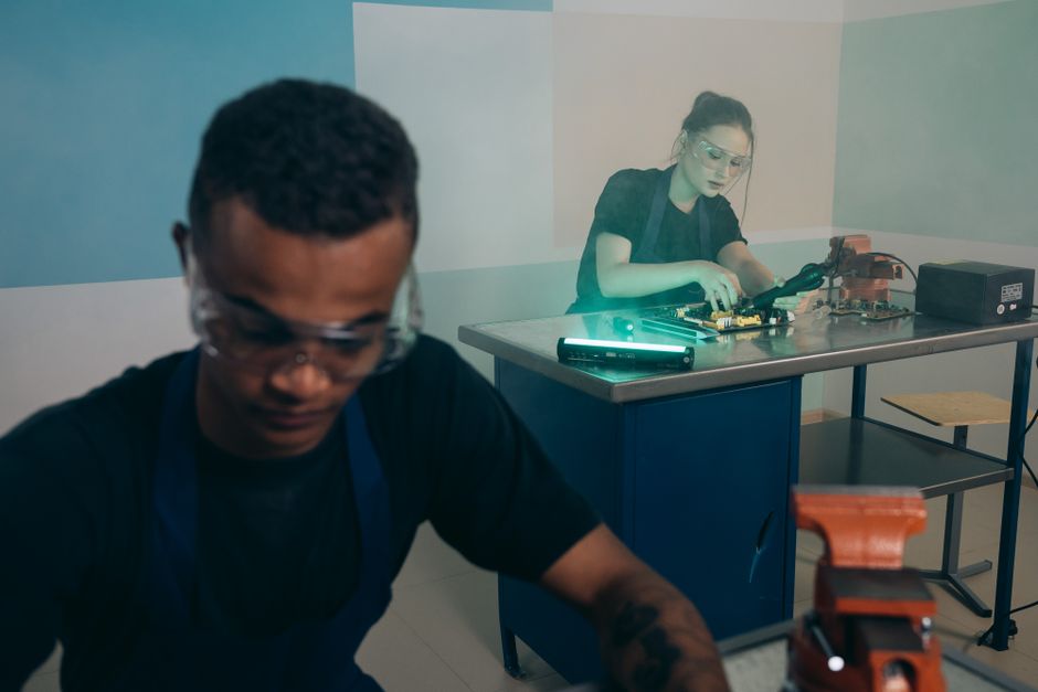 Dos técnicos concentrados en el trabajo de reparación de electrónica en un taller moderno.