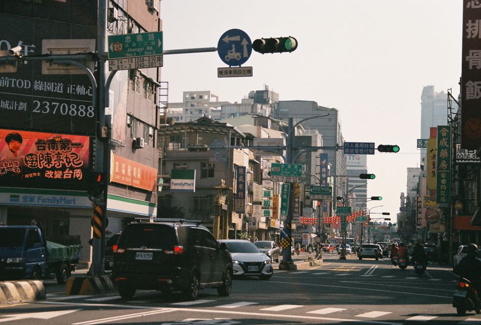 Una concurrida escena callejera en Taiwán que muestra el tráfico local y la señalización tradicional bajo la luz del día.
