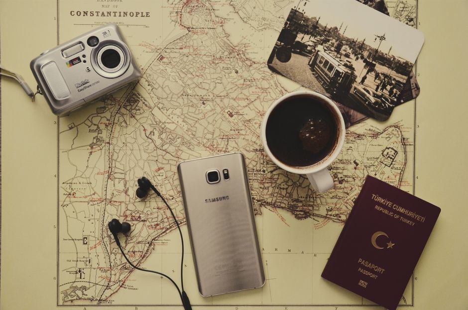 Cámara Plateada Cerca De Café Negro En Taza, Samsung Galaxy S7 Plateado, Pasaporte De Turquía Y Auriculares Negros