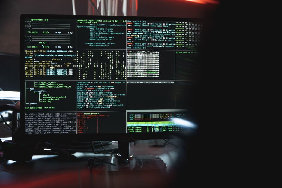 Primer plano de un monitor de computadora mostrando datos de ciberseguridad y código, indicativo de hacking de sistema o programación.