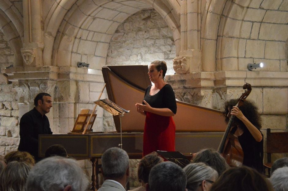 Una actuación en vivo de música clásica con cantante, pianista y violonchelista en un lugar histórico.