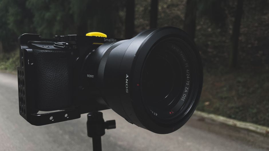 Foto de acercamiento de una lente profesional de cámara DSLR al aire libre con fondo natural.