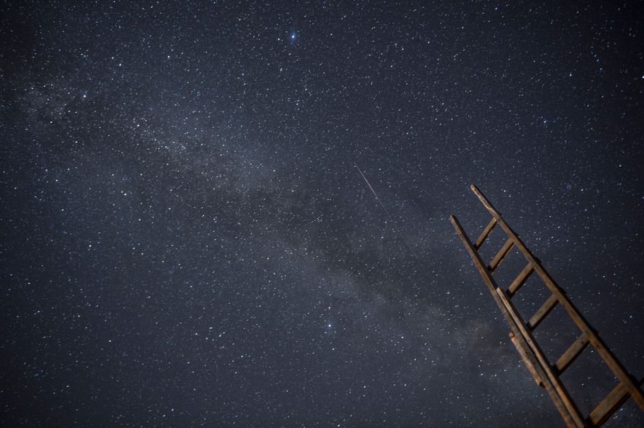 Una escalera de madera bajo un cielo estrellado, ideal para entusiastas de la astronomía.