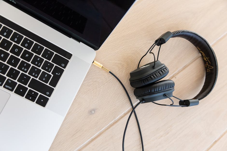 Auriculares Con Cable Negros Conectados A Macbook Pro Sobre Superficie De Madera Marrón