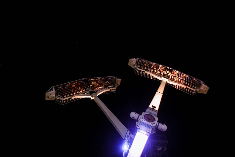Emocionante atracción iluminada de noche en un parque de atracciones, capturando la emoción y los buscadores de adrenalina.