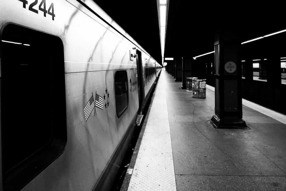 Dramática imagen en blanco y negro de una estación de metro de Nueva York con un andén y un tren vacíos.