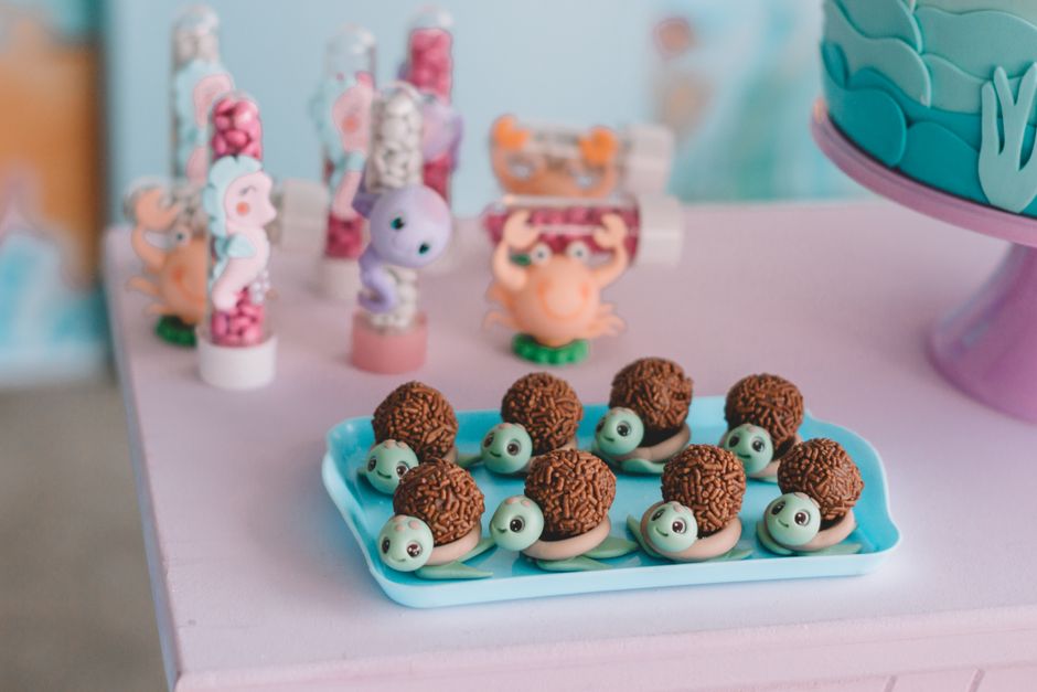 Adorables bocaditos de chocolate con temática de criaturas marinas en una bandeja, perfectos para una divertida y colorida fiesta infantil.
