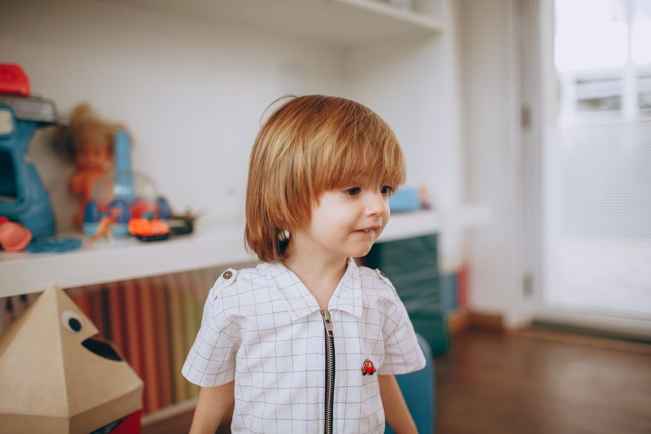 Un lindo niño disfrutando de su tiempo jugando en un vibrante ambiente de sala de juegos.