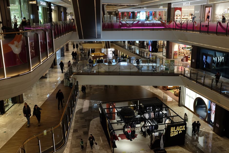 Amplio centro comercial cubierto con un diseño elegante, que cuenta con diversas tiendas y escaleras mecánicas.