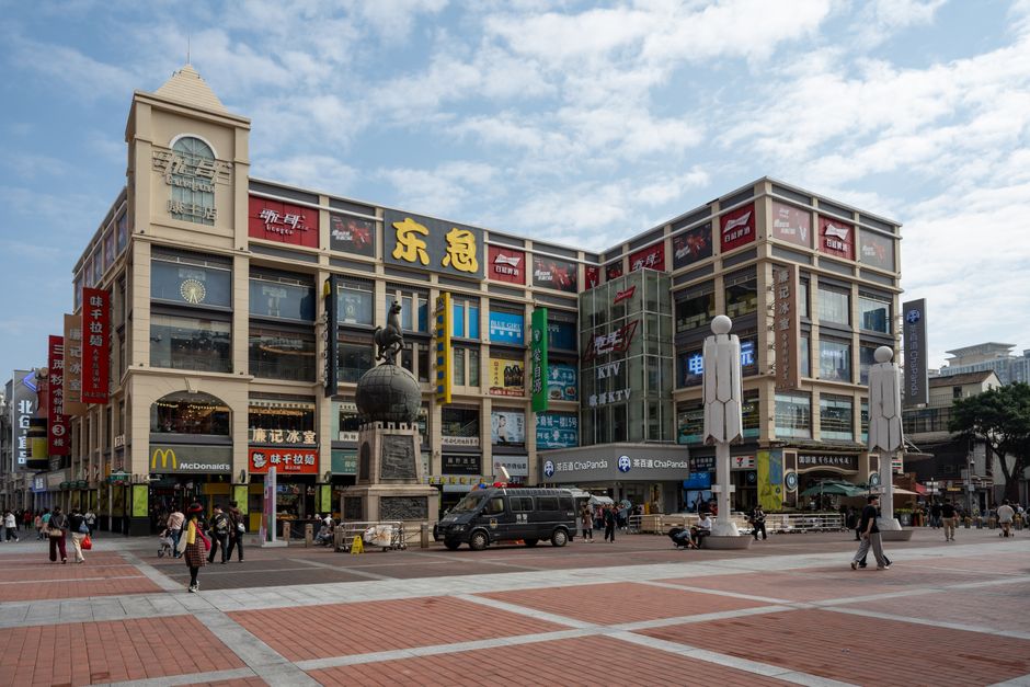 Una vibrante plaza comercial en Guangzhou que muestra una arquitectura moderna y una animada escena urbana.