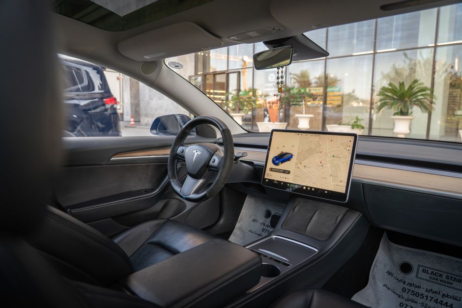Interior del Tesla Model 3 que muestra la pantalla de navegación y un diseño elegante, ideal para temas automotrices modernos.