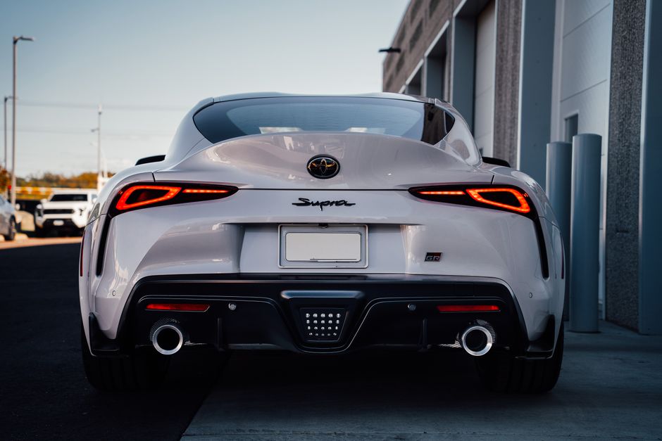 Cautivadora vista trasera de un automóvil deportivo blanco en un entorno urbano, que muestra un diseño moderno.