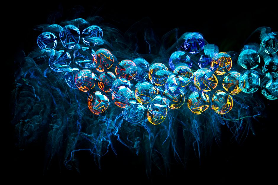 Formas abstractas de medusas neón coloridas con un diseño fractal futurista e iluminado sobre un fondo negro.