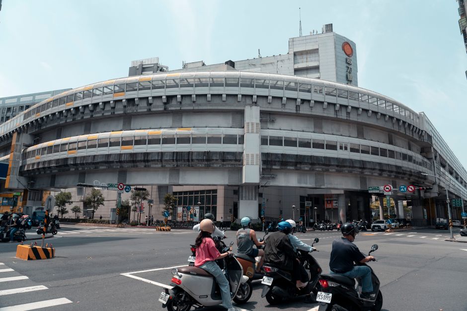 Vista de una concurrida intersección en la ciudad de Nuevo Taipéi, Taiwán, con motociclistas esperando en un semáforo.