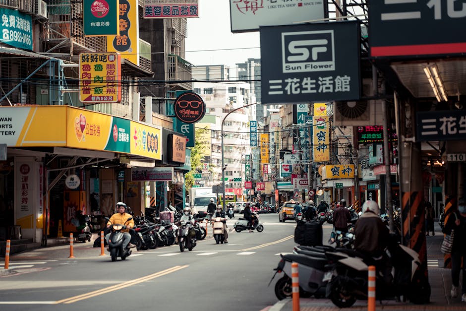 Calle vibrante llena de carteles y scooters en la ciudad de Nueva Taipei, Taiwán, que muestra la vida urbana.