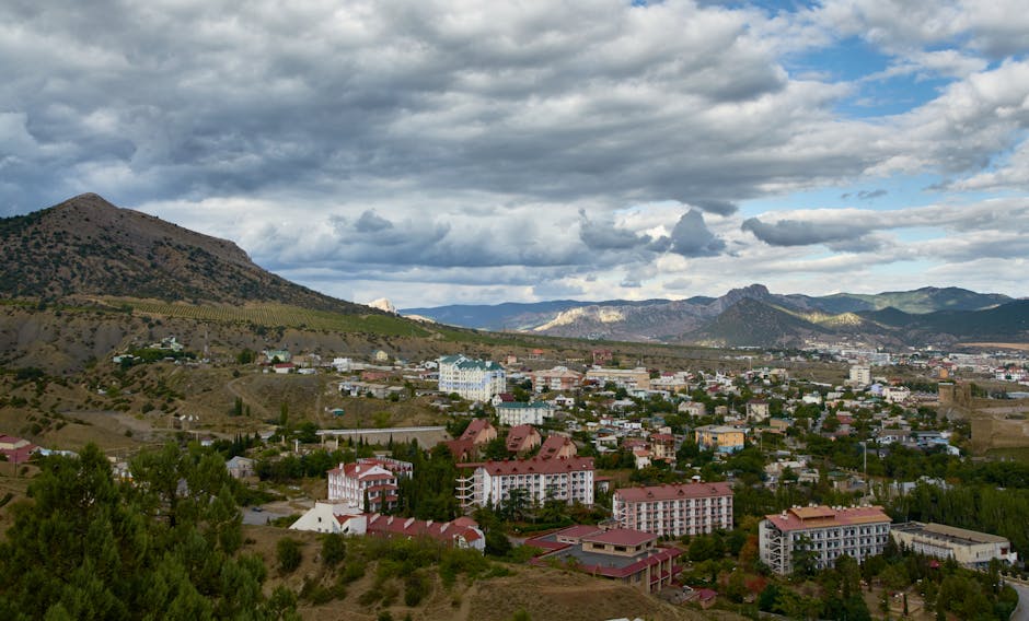 Una vista impresionante de un pueblo de Crimea enclavado entre montañas bajo un cielo nublado espectacular.