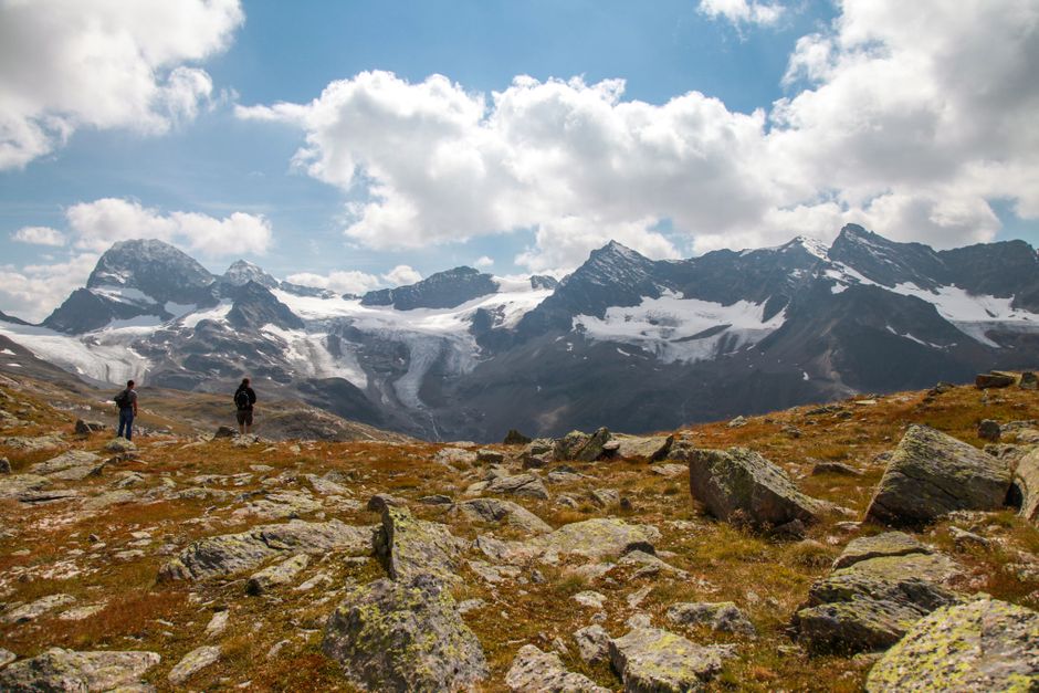 Impresionante vista de excursionistas explorando una montaña rocosa escénica bajo cielos nublados.