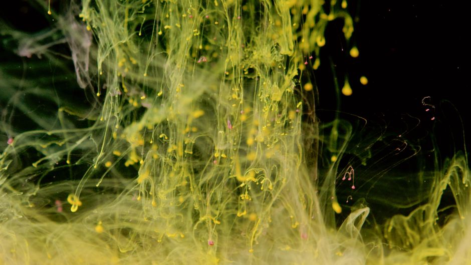 Arte abstracto vibrante con patrones de líquido amarillo sobre un fondo negro.