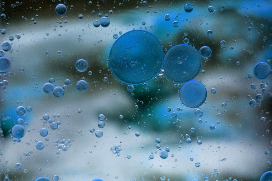 Primer plano artístico de burbujas azules flotando en líquido, creando una imagen abstracta serena.
