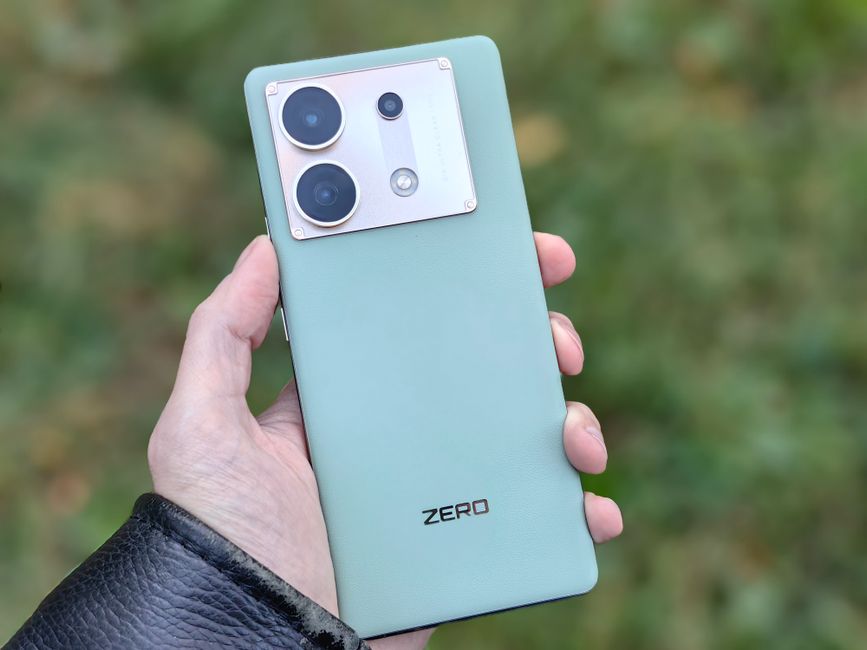 Toma de cerca de una mano sosteniendo un smartphone verde claro al aire libre en Moscú.