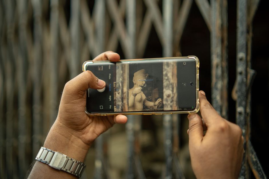 Una persona fotografía una estatua con un teléfono inteligente en Calcuta, India.