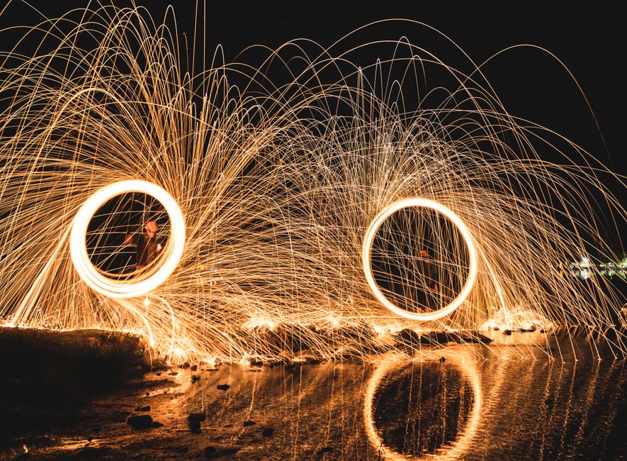 Hipnotizante exposición larga de pintura de luz con lana de acero junto al agua en Kayseri, Turquía por la noche.