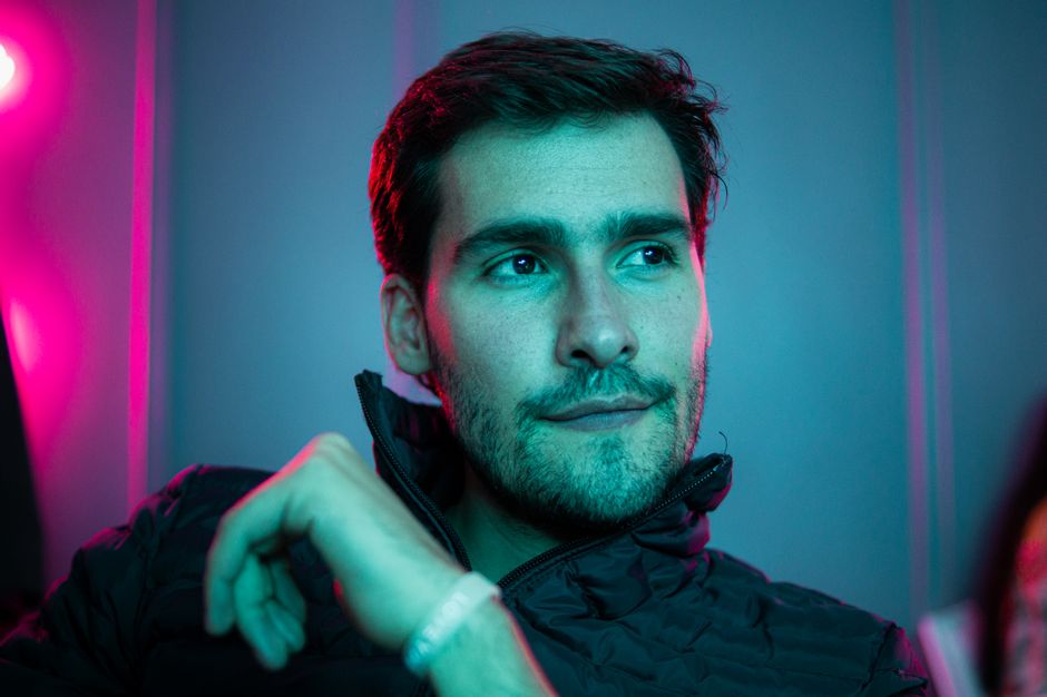Retrato de un hombre carismático bajo luces de neón, que irradia calma, confianza e individualidad.