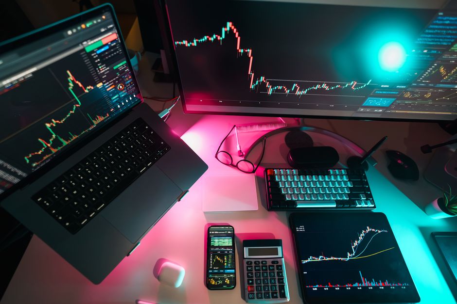 Configuración comercial de alta tecnología con gráficos digitales en múltiples dispositivos, ideal para profesionales de finanzas.