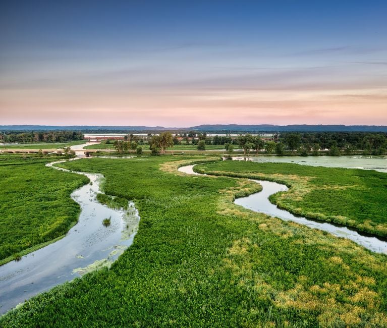 Pazful amanecer sobre un paisaje verde con un río serpenteante en Alma, Wisconsin.