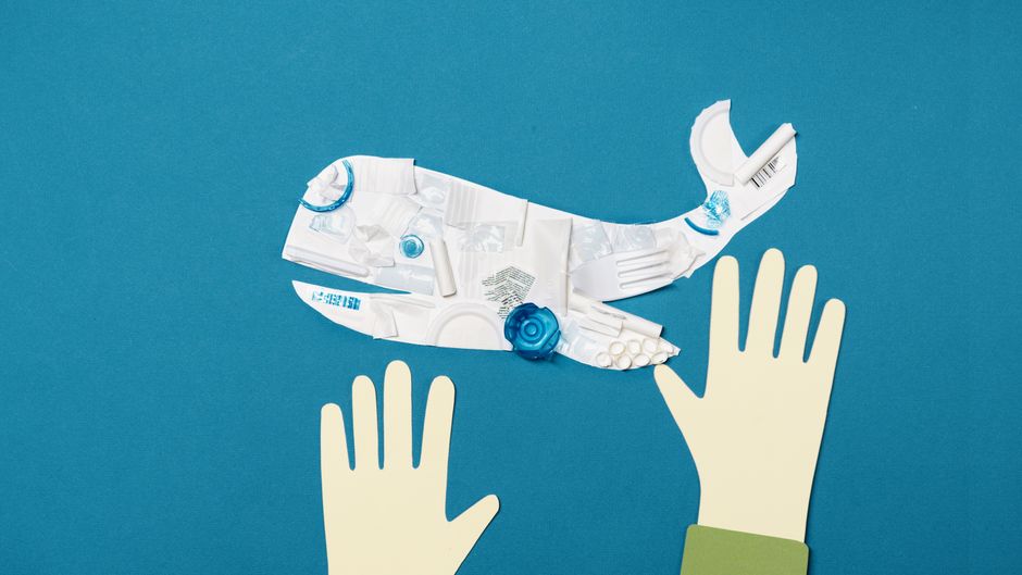 Ballena recortada de papel hecha con materiales reciclados sobre un fondo azul, enfatizando la conciencia ambiental.